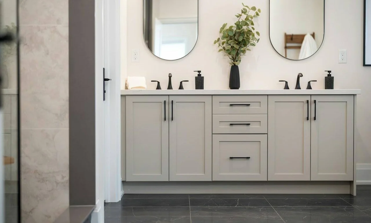 A bathroom vanity with two sinks and mirrors above the countertop.